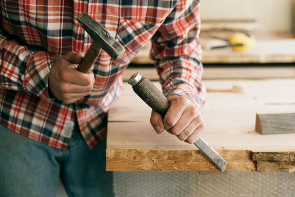 Person in Red White and Black Plaid Dress Shirt Holding Black Handle Knife